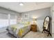 Bedroom with neutral tones, featuring a large bed and a decorative yellow and gray floral pattern at 2688 Stockbridge Way, Dacula, GA 30019
