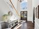 Bright and airy foyer featuring hardwood floors, a staircase, and a large arched window at 2688 Stockbridge Way, Dacula, GA 30019