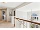 Upstairs hallway with view of chandelier and large window letting in natural light at 2688 Stockbridge Way, Dacula, GA 30019