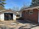 Back exterior view of a brick home showing a detached garage and access to the backyard at 496 Elizabeth Sw Ln, Mableton, GA 30126