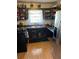 Functional kitchen features wood cabinets, laminate counters, black appliances and wood floors at 496 Elizabeth Sw Ln, Mableton, GA 30126