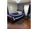 Bedroom featuring wood floors, dark curtains, and a comfortable bed with a blue and white comforter at 496 Elizabeth Sw Ln, Mableton, GA 30126