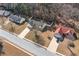 Aerial shot of a neighborhood featuring a home with a well-maintained lawn and a driveway, surrounded by trees at 55 Vintage Dr, Covington, GA 30014