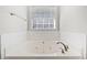 Relaxing bathtub with jets, tile surround, and chrome fixtures at 55 Vintage Dr, Covington, GA 30014