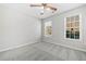 Bright bedroom featuring neutral walls, a ceiling fan, and carpeted floors with natural light from two windows at 55 Vintage Dr, Covington, GA 30014