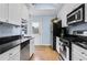 Modern kitchen featuring white cabinets, black countertops, and stainless steel appliances at 818 Virgil Ne St, Atlanta, GA 30307