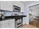 Well-lit kitchen featuring white cabinets, stainless steel appliances, and black countertops at 818 Virgil Ne St, Atlanta, GA 30307
