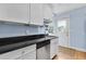 Well-lit kitchen with white cabinets, black countertops, and view to exterior door at 818 Virgil Ne St, Atlanta, GA 30307