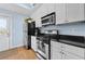Modern kitchen featuring white cabinets, black countertops, and stainless steel appliances at 818 Virgil Ne St, Atlanta, GA 30307