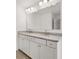 Bathroom with a granite countertop, double sinks, white cabinets and an oversized mirror at 1868 Lacebark Elm Way, Lawrenceville, GA 30045