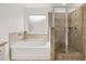 Well-lit bathroom featuring tiled shower with glass doors and a soaking tub at 1868 Lacebark Elm Way, Lawrenceville, GA 30045