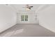Bright bedroom featuring a ceiling fan, tray ceiling, and abundant natural light at 1868 Lacebark Elm Way, Lawrenceville, GA 30045