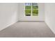 Neutral toned bedroom with carpet and a window overlooking a green landscape at 1868 Lacebark Elm Way, Lawrenceville, GA 30045