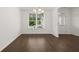 Bright dining area with hardwood floors, large window and modern chandelier lighting fixture at 1868 Lacebark Elm Way, Lawrenceville, GA 30045