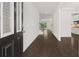 Hallway with hardwood floors, staircase, and views into a modern kitchen. Creates a cohesive living space at 1868 Lacebark Elm Way, Lawrenceville, GA 30045
