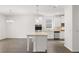 Open kitchen featuring an island, stainless appliances, and modern lighting at 1868 Lacebark Elm Way, Lawrenceville, GA 30045