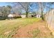 Spacious backyard with a fence, green grass, mature trees, and outbuildings for outdoor activities at 2976 Emory Se Rd, Smyrna, GA 30080