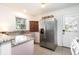 Well-lit kitchen with granite counters, stainless steel fridge, vintage cabinets, and a door that leads to the outside at 2976 Emory Se Rd, Smyrna, GA 30080