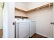 Well-organized laundry room featuring white front load machines and wooden shelving for ample storage at 2976 Emory Se Rd, Smyrna, GA 30080