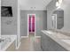 Bathroom featuring double sinks, granite countertops, soaking tub, and gray walls at 115 Trelawney Cir, Covington, GA 30016