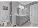 Bathroom featuring a toilet, double sink vanity, and white and gray walls at 115 Trelawney Cir, Covington, GA 30016