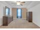 Bedroom featuring two dressers, a ceiling fan, neutral walls and floors, and light blue curtains at 115 Trelawney Cir, Covington, GA 30016