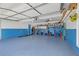 Spacious garage with blue and white walls and epoxy floor at 115 Trelawney Cir, Covington, GA 30016