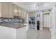 Kitchen features modern countertop, tile backsplash, and convenient barstool seating at 115 Trelawney Cir, Covington, GA 30016