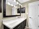 Bathroom featuring a black framed mirror and black drawers under a white sink at 1406 River Green Nw Dr, Atlanta, GA 30327