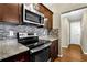 Kitchen with granite countertops, stainless steel oven, stovetop, microwave and backsplash at 1406 River Green Nw Dr, Atlanta, GA 30327