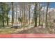 Backyard view featuring landscaping, trees, greenery, and a storage shed in the background at 2090 Walden Park, Snellville, GA 30078