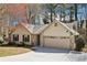 This single-story home showcases stone accents and a spacious driveway leading to the two-car garage at 2090 Walden Park, Snellville, GA 30078