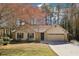 Charming single-story home with a two-car garage and stone accents, surrounded by mature trees at 2090 Walden Park, Snellville, GA 30078
