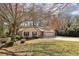 The house sits amidst mature trees and has a long driveway leading to its two-car garage at 2090 Walden Park, Snellville, GA 30078