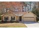 Inviting single-story home with a two-car garage, stone details, and a well-maintained lawn at 2090 Walden Park, Snellville, GA 30078