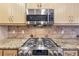 Kitchen detail of stovetop with stainless steel microwave and granite countertops at 2090 Walden Park, Snellville, GA 30078