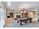 Open basement layout with a pool table, fireplace, built-in shelves, and access to natural light at 3832 Wesley Chapel Rd, Marietta, GA 30062