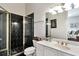 Bathroom featuring a glass-door shower with black tile, a vanity, and a large mirror at 3832 Wesley Chapel Rd, Marietta, GA 30062
