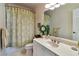 Well-lit bathroom featuring a decorative shower curtain, ample counter space, and a serene ambiance at 3832 Wesley Chapel Rd, Marietta, GA 30062