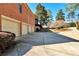 Side view of all three garage doors on this all brick home with a long driveway at 3832 Wesley Chapel Rd, Marietta, GA 30062
