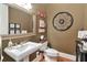 Elegant powder room featuring a pedestal sink, decorative mirror, and earth-toned walls at 3832 Wesley Chapel Rd, Marietta, GA 30062