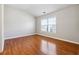 Empty bedroom featuring hardwood floors, a window for natural light, and neutral walls at 4550 Cold Spring Ct, Cumming, GA 30041