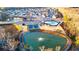 An aerial view showcasing the community layout with a pool, tennis courts, and a scenic pond at 1069 Blue Juniper Cir, Loganville, GA 30052