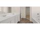 Bathroom with double sink vanity with a mirror and modern wood-look tile at 1069 Blue Juniper Cir, Loganville, GA 30052