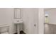 Bathroom featuring a toilet and pedestal sink on hardwood flooring near a bright door at 1069 Blue Juniper Cir, Loganville, GA 30052