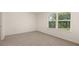 Bright bedroom featuring a window with a view of mature trees at 1069 Blue Juniper Cir, Loganville, GA 30052