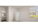 Bright bedroom with a walk-in closet and view of the outdoors through a window with bright white trim at 1069 Blue Juniper Cir, Loganville, GA 30052