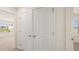 Hallway with double closets and a view into a well-lit room with a window at 1069 Blue Juniper Cir, Loganville, GA 30052