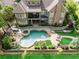 Aerial view showcases the expansive backyard with pool, spa, patio, and lush greenery of the property at 8760 Colonial Pl, Duluth, GA 30097