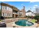 Large brick home backyard featuring a pool, spa, stone patio, and manicured landscaping at 8760 Colonial Pl, Duluth, GA 30097